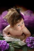 porträtt av en söt liten flicka. bebis ligger i färgerna av lila hortensia foto