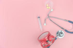 ovanifrån med kopia utrymme av stetoskop på den rosa bakgrunden, medicinska och hälsosamma koncept foto