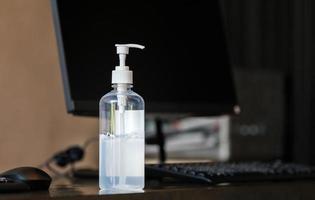 handsprit alkohol gel pumpflaska på bordet på kontoret, hälsovård och covid-19 coronavirus koncept foto