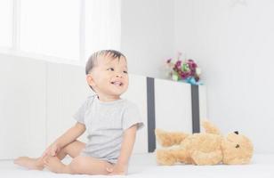 lycka och leende pojke skrattar på sängen, barn spelar koncept foto