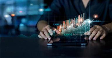 affärsman använder tablett analysera försäljningsdata och ekonomisk tillväxt grafdiagram. affärsplanering och strategi. analysera börshandel. finans och bank. teknik digital marknadsföring. foto