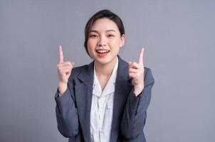 porträtt av en vacker asiatisk affärskvinna på en grå bakgrund foto
