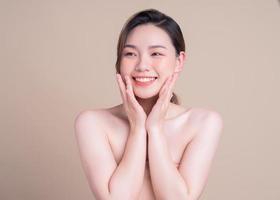 attraktiv ung asiatisk kvinna med frisk hud. ansiktsvård, ansiktsbehandling,, kvinna skönhet hud isolerad på vit bakgrund. kosmetologi, skönhet hud och kosmetiska koncept foto