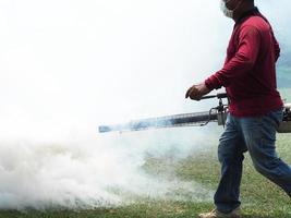 ung man arbetare arbetar imma för att eliminera myggor foto