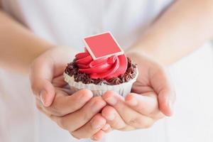 hand hålla alla hjärtans cupcake foto