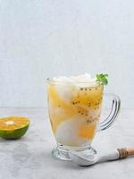 es kelapa jeruk, en typisk indonesisk drink gjord på färska apelsiner pressade med riven ung kokosnöt. foto
