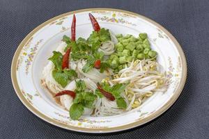 risnudlar i fiskcurrysås med grönsaker eller thailändsk vermicelli som äts med curry är thaimat. rätten är utsökt och kryddig mat. foto