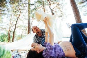 gravid kvinna med sin man på picknick foto