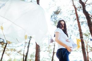 gravid kvinna som håller händerna på magen foto