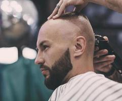 mans frisyr, en frisör klipper hans hår foto