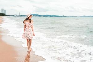 ung asiatisk kvinna koppla av på stranden foto