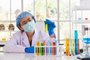 en asiatisk kvinnlig forskare forskar om en kemisk formel i ett labb. foto