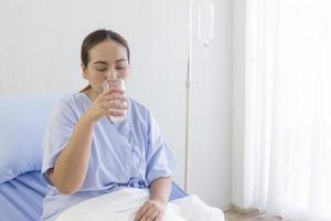 asiatiska kvinnliga patienter dricksvatten foto