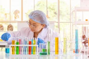 en asiatisk kvinnlig forskare forskar om en kemisk formel i ett labb. foto