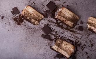 traditionell italiensk dessert tiramisu. några bitar på bordet är utspridda. foto