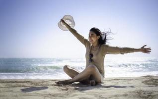 le vacker asiatisk turist kvinna avkopplande sittande på sand havsstrand foto