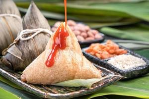 zongzi, ångade risdumplings med chilisås. närbild, kopiera utrymme, berömd asiatisk välsmakande mat i drakbåt duanwu festival foto