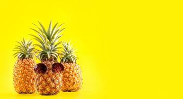 kreativ ananas tittar upp med solglasögon och skal isolerad på gul bakgrund, designmönster för sommarsemesterstrandidé, kopieringsutrymme närbild foto