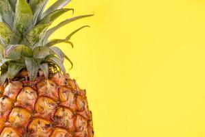 vacker färsk ananas isolerad på ljusgul bakgrund, sommar säsongsbetonad frukt design idémönster koncept, kopieringsutrymme, närbild foto