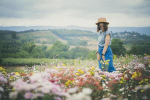 kvinna som står i blommande blomsterträdgård med avkopplande humör foto