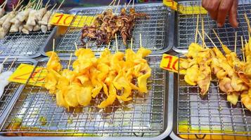 bläckfiskspett förbereder för grill som kallas muek yang på den lokala marknaden. foto