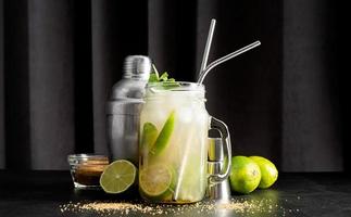 färsk sommar caipirinha cocktail på en svart gardin bakgrund foto