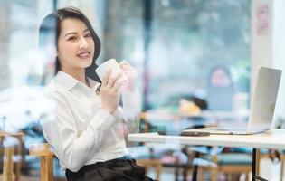 asiatisk affärskvinna som arbetar på ett café foto