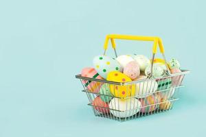 glad påsk. färgade påsk målade ägg i en varukorg med kopia utrymme foto