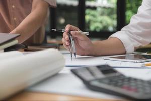 team av arkitekter eller ingenjörer diskuterar på skrivbordet med ritning om nytt startprojekt på skrivbordet. teamgrupp på konstruktionsplats kontrollera dokument och affärsflöde. selektivt fokus. foto