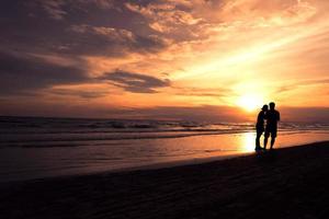par som går vid havets strandlinje foto