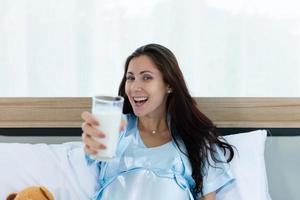 gravid kvinna i sovrummet med morgonatmosfär med mjölk foto