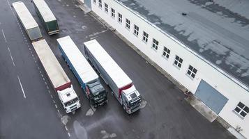 lastbilar väntar på att bli lastade i logistikcentret ovanifrån flygfotografering från en drönare foto