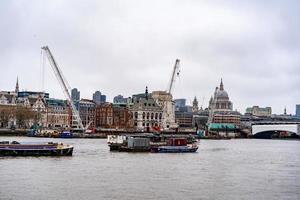 london skyline grå moln med flodtrafik foto