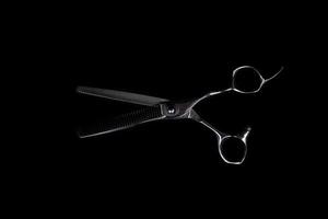en uppsättning hårklippningsverktyg på svart bakgrund för att klippa frisörskäggsalong foto