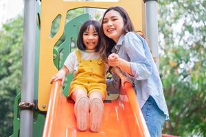 asiatisk mor och dotter spelar tillsammans i parken foto