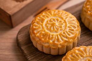 rundformad moon cake mooncake - traditionellt bakverk i kinesisk stil under midhöstfestivalen månfestival på träbakgrund och bricka, närbild foto