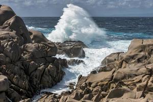 vågorna slår mot kusten vid capo testa sardinien foto