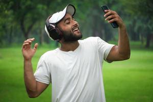 man njuter av musiken i parken foto