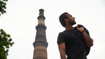 indisk ung stilig man vid historiska palatset qutub minar resa i Indien bild foto