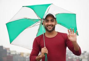 man med paraply porträtt av en stilig indisk man foto