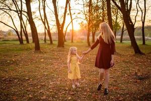 far, dotter och mamma går utomhus. glad familj. foto