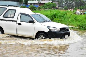 pickup bil och fordon i översvämningsvatten, bilförsäkring och farlig situation koncept. foto