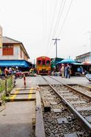 samut songkhram-thailand - 1 maj 2021 ett vackert röd-gult gammalt tåg som går in på perrongen. foto