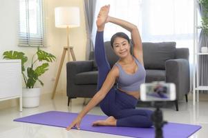 professionell yogacoach som undervisar onlineträningsklass för studenter under livestreaming på sociala medier, hälsokoncept foto