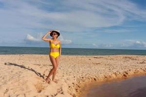 vältränade kvinnor i en gul bikini på stranden känd som pitinga, i arraial d ajuda, Bahia, Brasilien foto