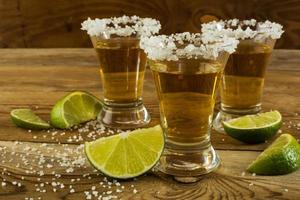 guld mexikansk tequila med lime och salt på nära håll foto