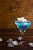 blå kosmopolitisk cocktail på trä bakgrund foto