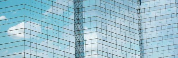moln reflekteras i fönster i modern kontorsbyggnad. foto