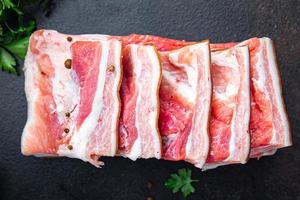 magen kött bacon bit kött fett ister färskt fläsk i kryddor färsk måltid på bordet kopia utrymme mat bakgrund foto