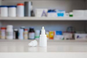 ögon örondroppar medicin flaska med apotek butik hyllor bakgrund foto